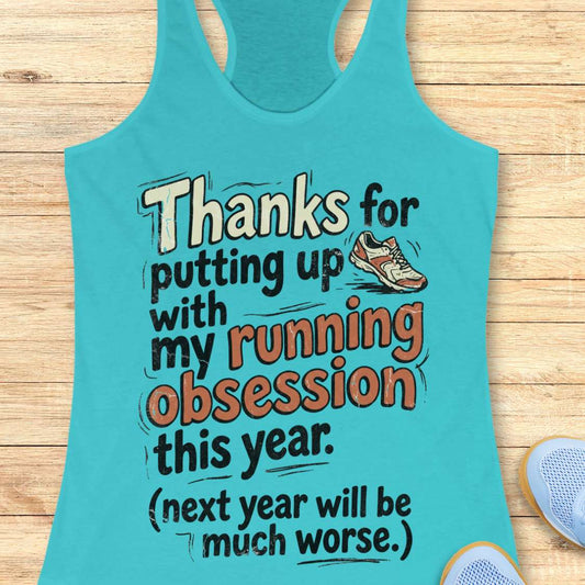 Turquoise tank top with humorous running text on a wooden surface
