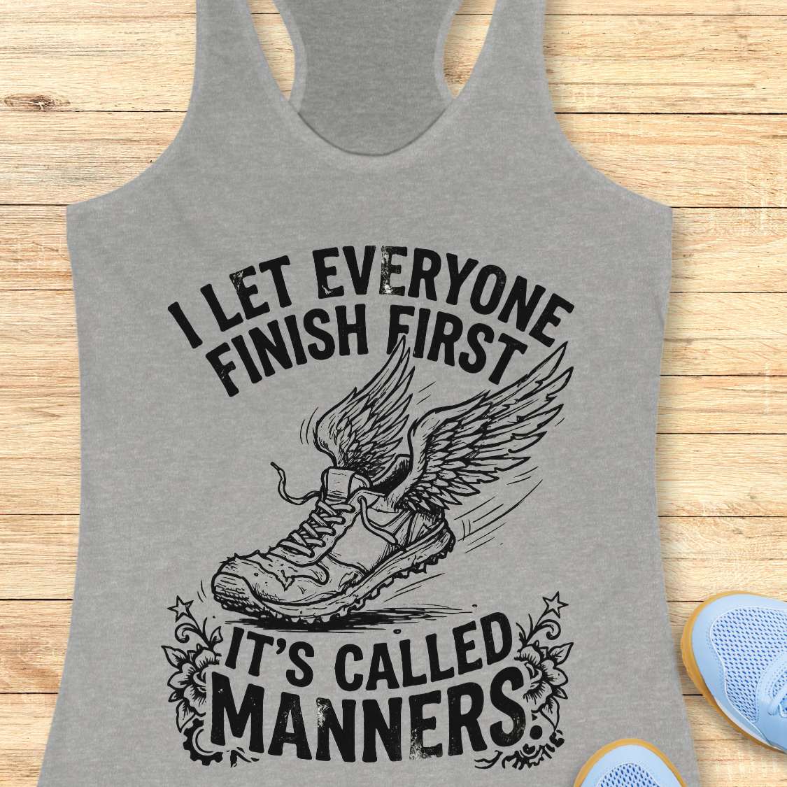 Gray tank top with a graphic and text on a wooden surface