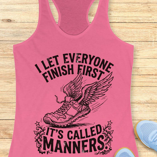 Pink tank top with black graphic and text on a wooden surface