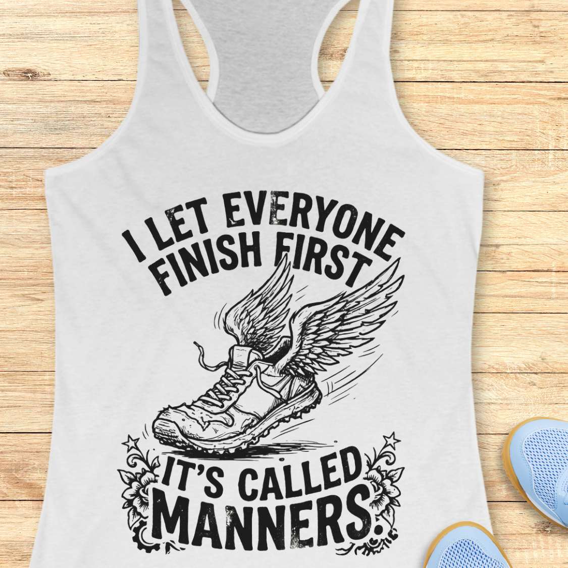White tank top with black graphic and text on a wooden surface