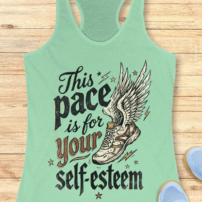 Mint green tank top with motivational quote and shoe graphic on a wooden surface