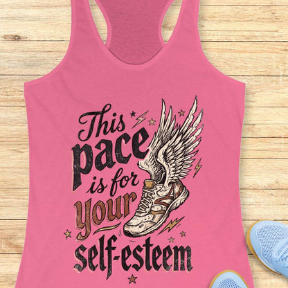 Pink tank top with motivational quote and shoe graphic on a wooden surface