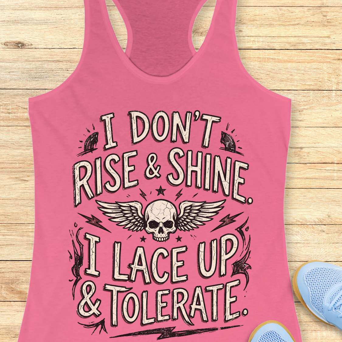 Pink tank top with skull design and text on a wooden surface