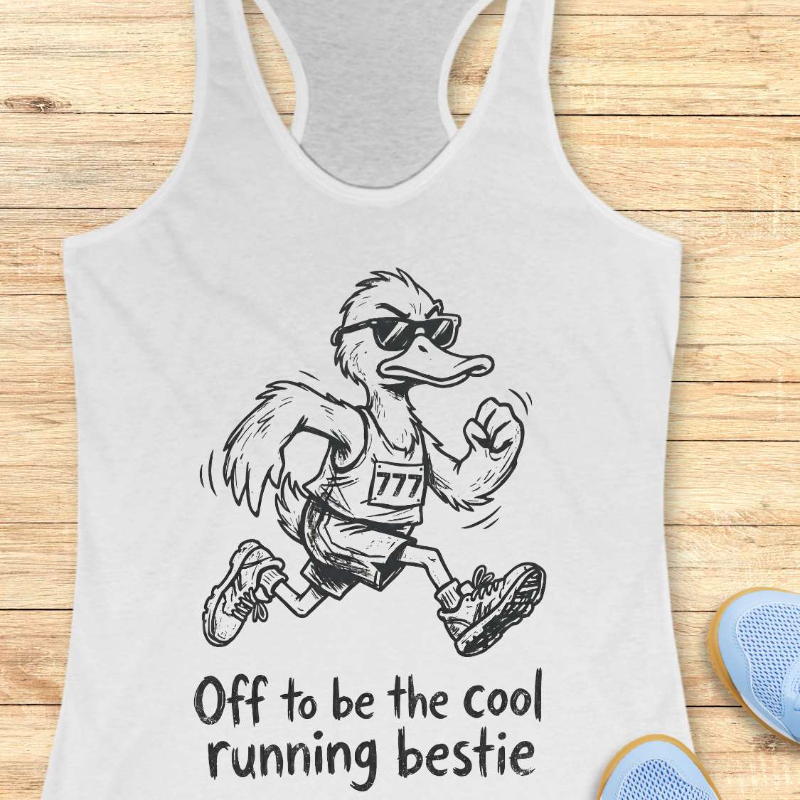 white tank top with a cartoon ostrich running and sunglasses on, text 'Off to be the cool running bestie' on a wooden surface.
