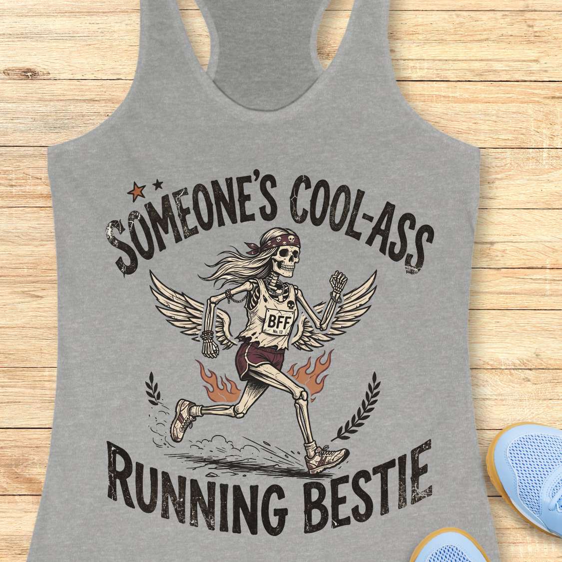 Gray tank top with skeleton design and text on a wooden surface