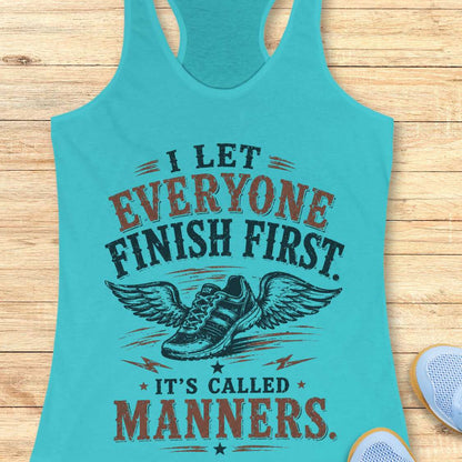 Turquoise tank top with motivational quote "I let everyone finish first. It's called manners." on a wooden surface