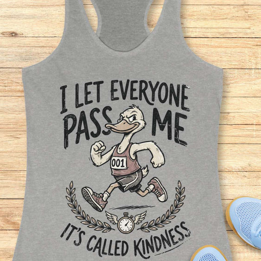 Gray tank top with a graphic of a running duck and text - I let everyone pass me, it's called kindness, on a wooden surface