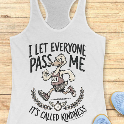 white tank top with a graphic of a duck and text I let everyone pass me, it's called kindness, on a wooden surface