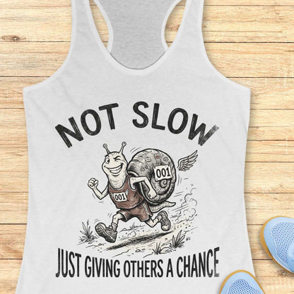 white tank top with a snail graphic and text - not slow, just giving others a chance, on a wooden surface