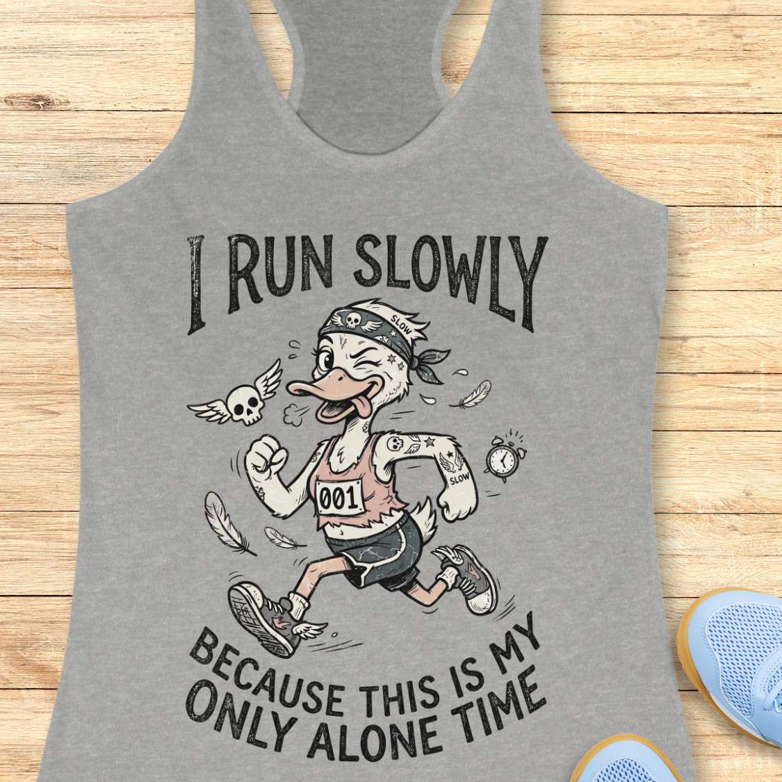 Gray tank top with cartoon character and text 'I Run Slowly Because This is My Only Alone Time' on a wooden surface.