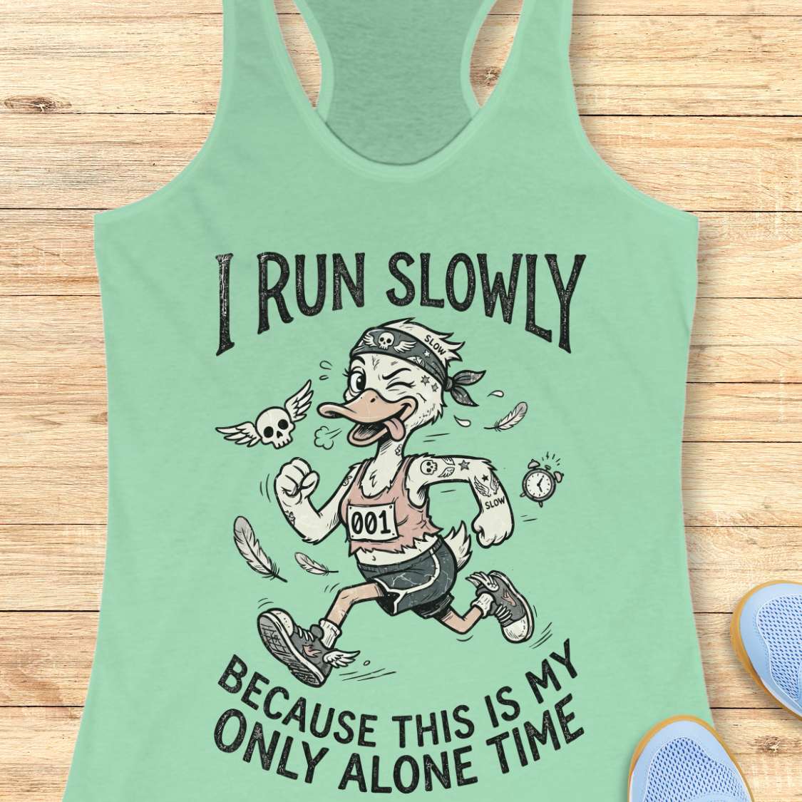 Mint green tank top with cartoon duck design and text - I run slowly, because this is my only alone time, on a wooden surface
