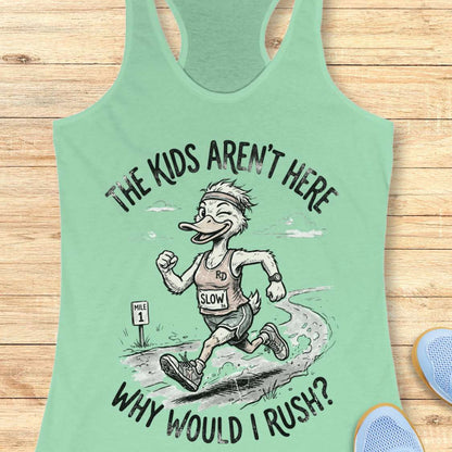 Mint green tank top with cartoon character and text - the kids aren't here, why would I rush?, on a wooden surface