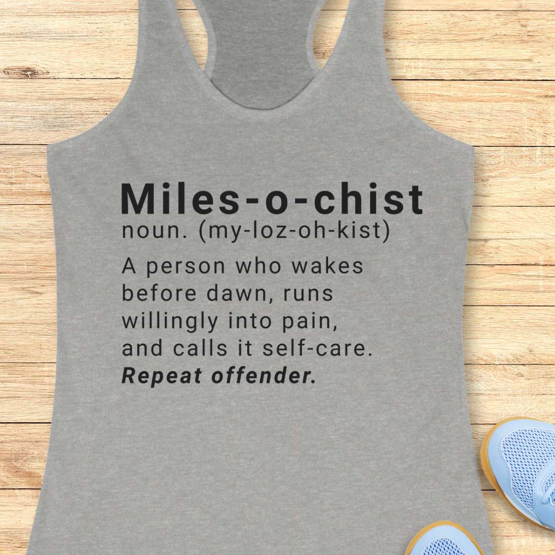 Gray tank top with humorous definition text on a wooden surface