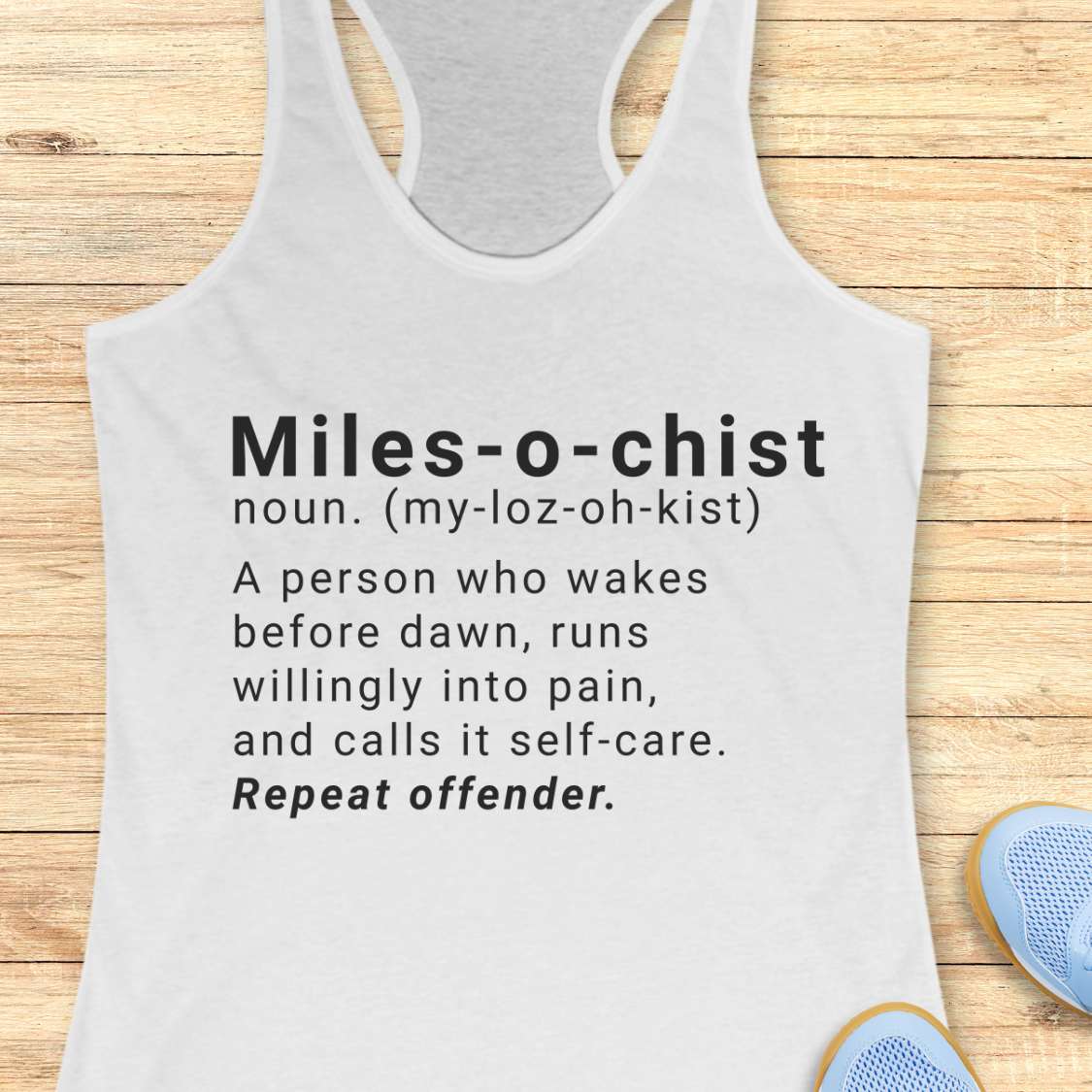 white tank top with humorous text on a wooden surface