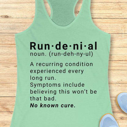 Green tank top with humorous definition text  of run de ni al  on a wooden surface