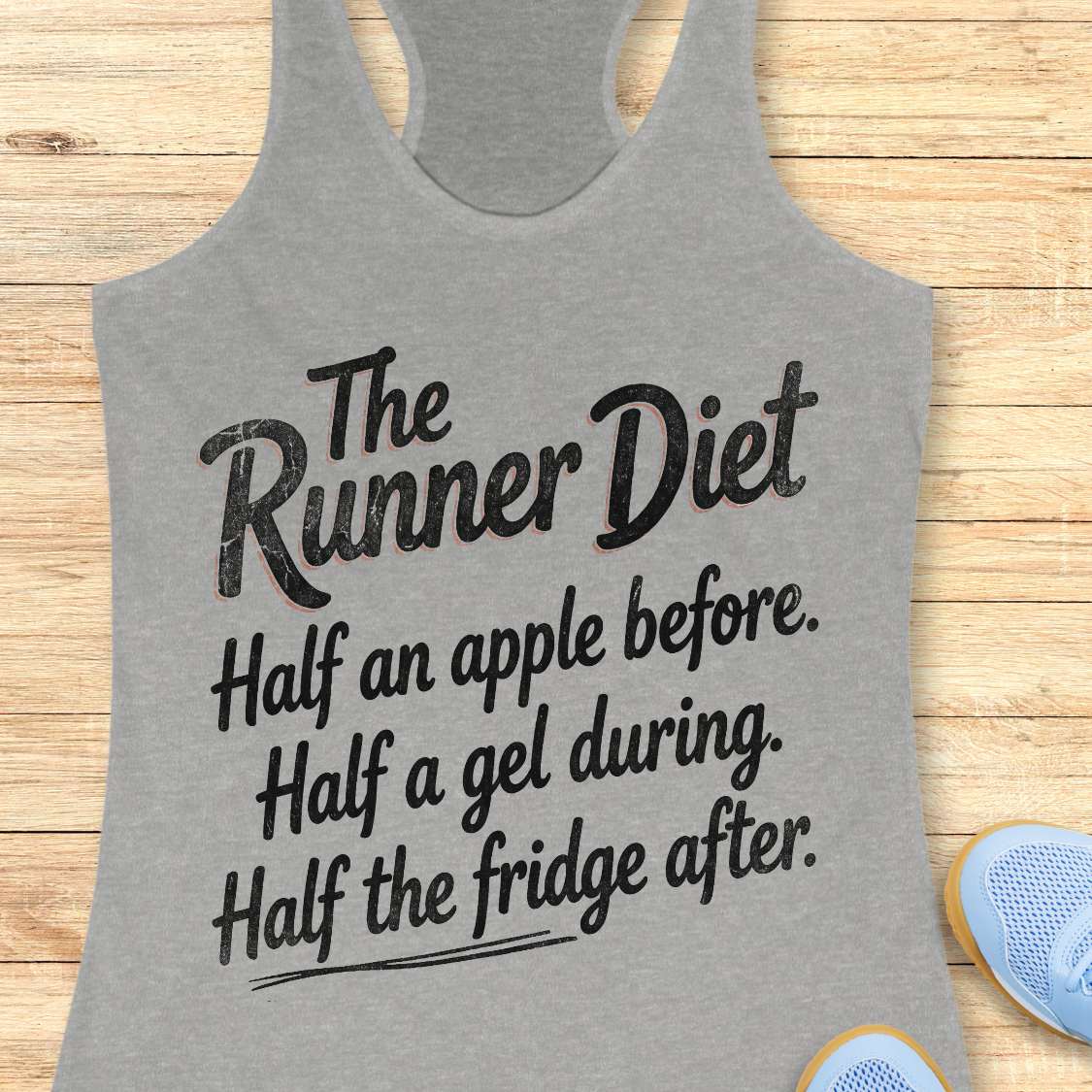 Gray tank top with humorous text  about the runner diet design on a wooden surface