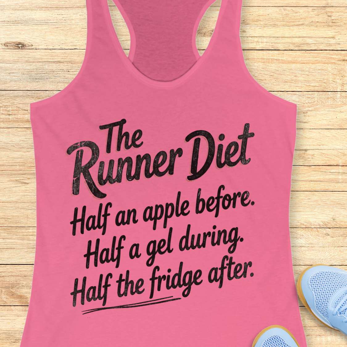 Pink tank top with humorous text about the runner diet on a wooden surface
