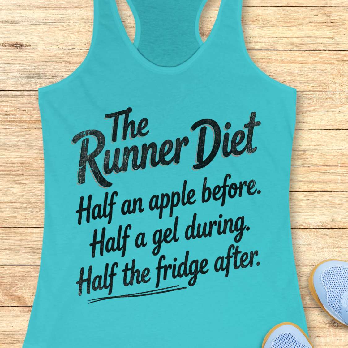 Turquoise tank top with humorous text about the runner diet on a wooden surface