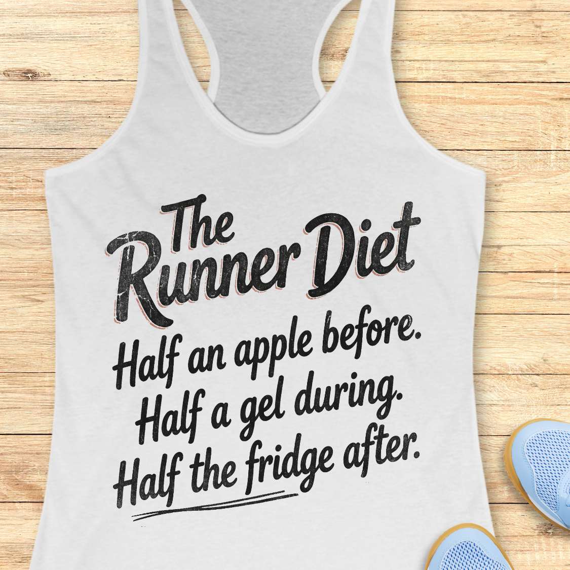 Gray tank top with humorous running text about the runner diet on a wooden surface