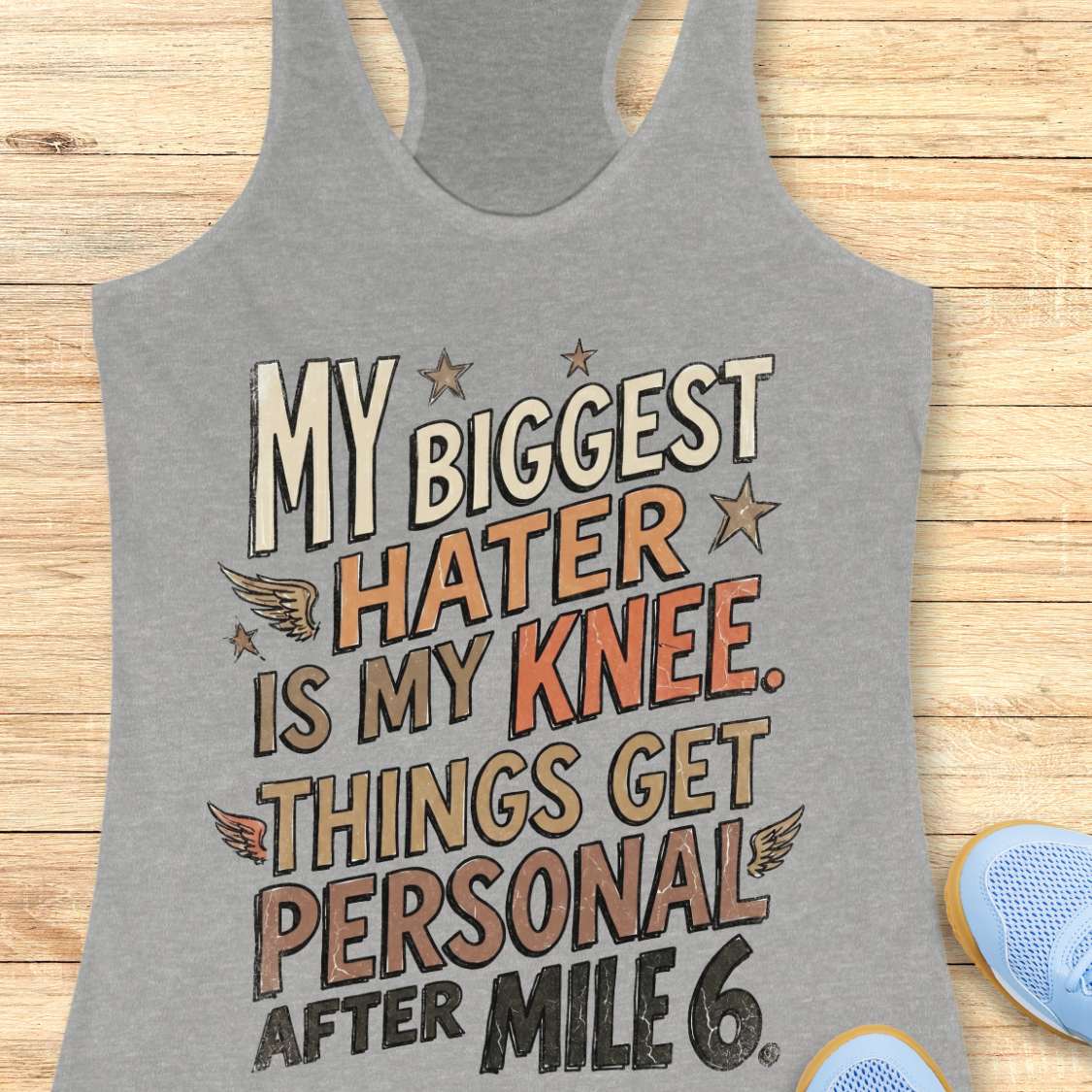 Gray tank top with motivational text on a wooden surface