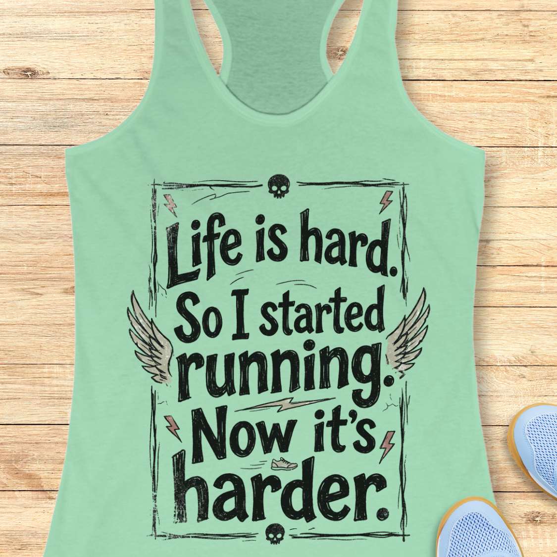 Green tank top with a text - life is hard. So I started running. Now it's harder on a wooden surface