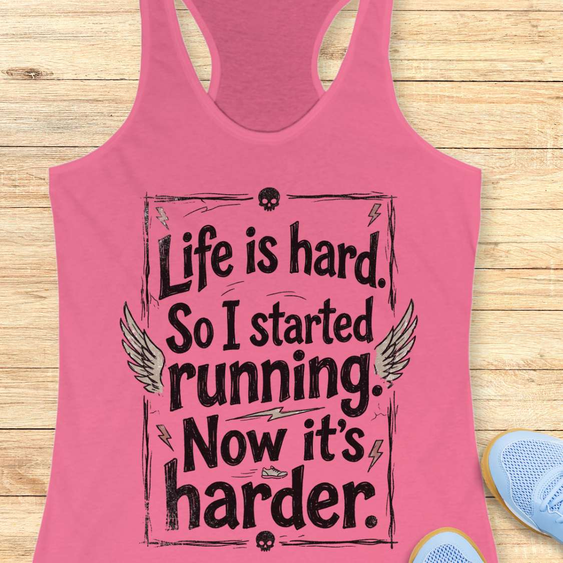 Pink tank top with a text - life is hard. So I started running. Now it's harder on a wooden surface