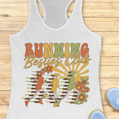 White tank top with 'Running Besties Club' design on a wooden surface
