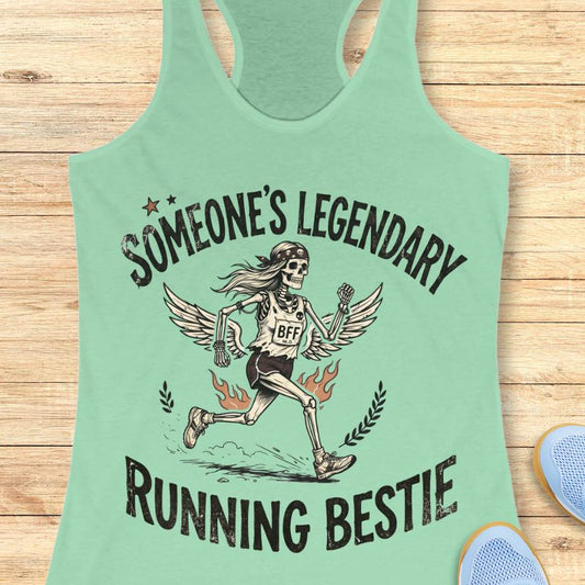 Mint green tank top with skeleton design and text someone's legendary running bestie on a wooden surface
