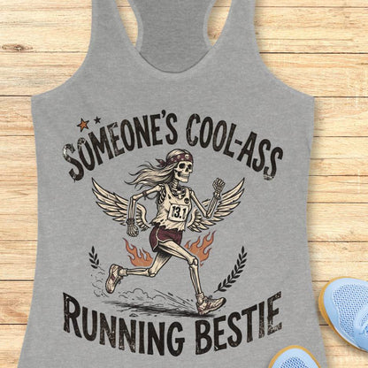 Gray tank top with skeleton runner graphic and text someone's cool-ass running bestie on a wooden surface