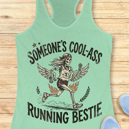 Light green tank top with skeleton graphic and text someone's cool-ass running bestie on a wooden surface