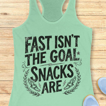 Mint green tank top with black text fast isn't the goal, snacks are, on a wooden surface