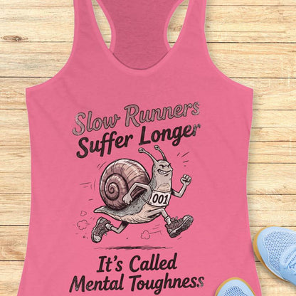 Pink tank top with a snail graphic and text on a wooden surface