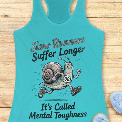 Turquoise tank top with a snail graphic and text on a wooden surface
