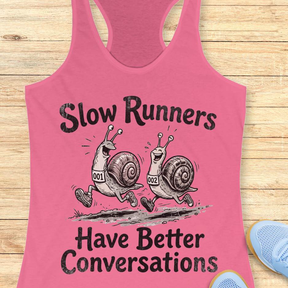 Pink tank top with snail design and text 'Slow Runners Have Better Conversations' on a wooden surface.