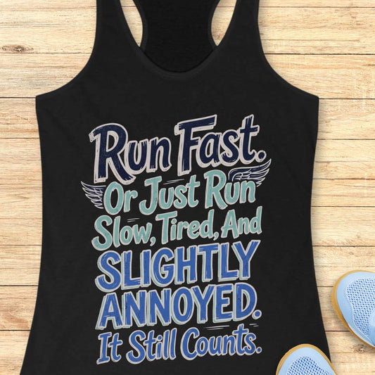 Black tank top with humorous text design "Run fast. Or just run slow, tired, and slightly annoyed. It still counts." on a wooden surface