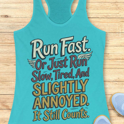 Turquoise tank top with humorous running text "Run fast. Or just run slow, tired, and slightly annoyed. It still counts." on a wooden surface