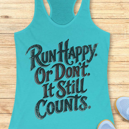 Turquoise tank top with motivational text Run happy. Or Don't It still counts. on a wooden surface