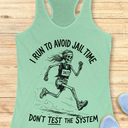 Mint green tank top with skeleton graphic and text i run to avoid jail time don't test the system  on a wooden surface