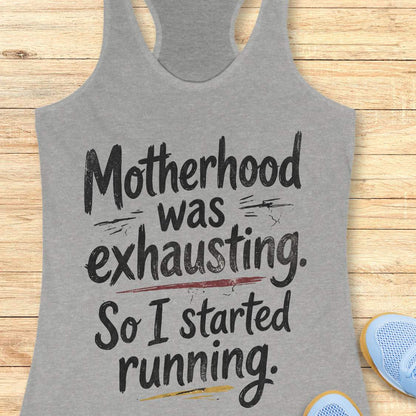 Gray tank top with humorous text motherhood was exhausting. So I started running.  on a wooden surface