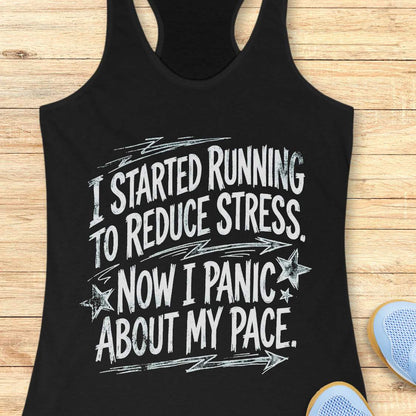 Black tank top with humorous running text I started running to reduce stress. Now I panic about my pace.  on a wooden surface