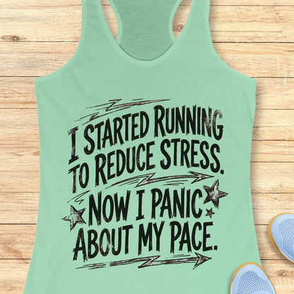 Mint green tank top with humorous running text I started running to reduce stress. Now I panic about my pace.  on a wooden surface
