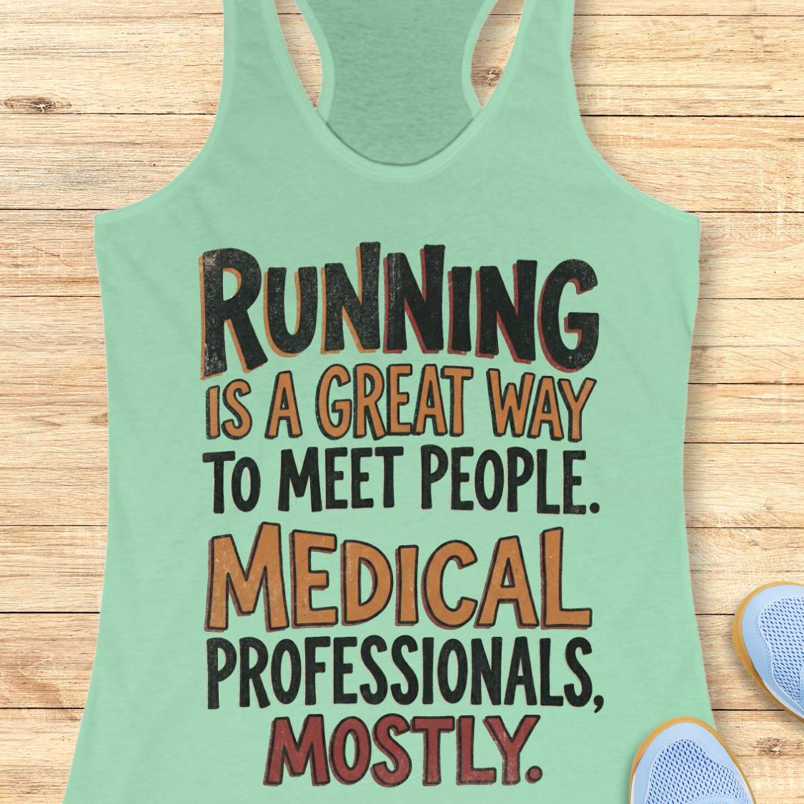 Mint green tank top with humorous text on a wooden surface