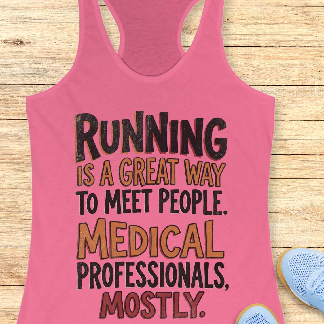 Pink tank top with humorous text on a wooden surface
