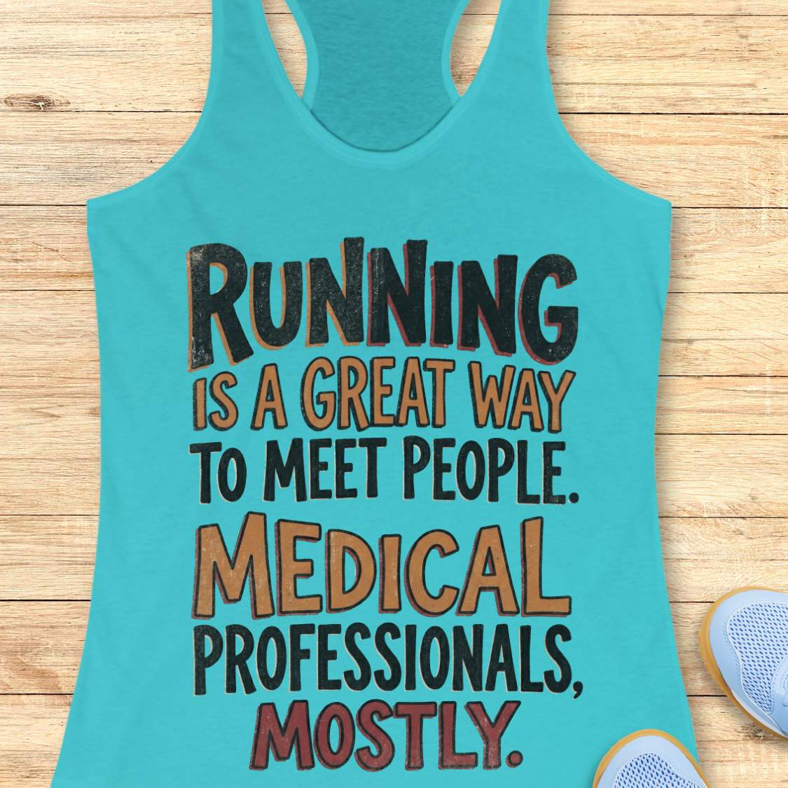 Turquoise tank top with humorous text on a wooden surface