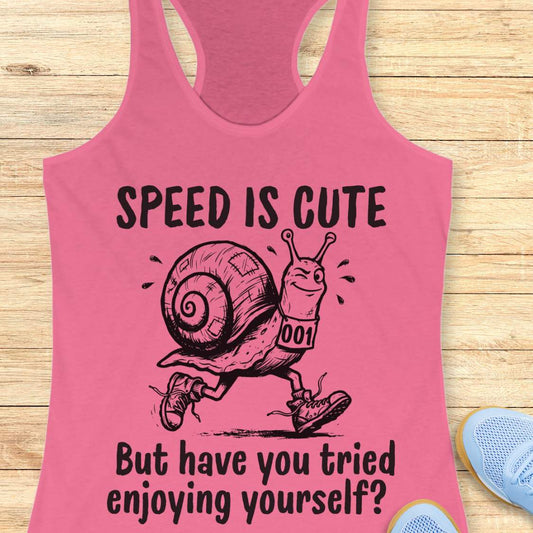 pink tank top with a snail image and text - speed is cute but have you tried enjoying yourself? on a wooden background