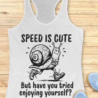 white tank top with a snail image and text - speed is cute but have you tried enjoying yourself? on a wooden background