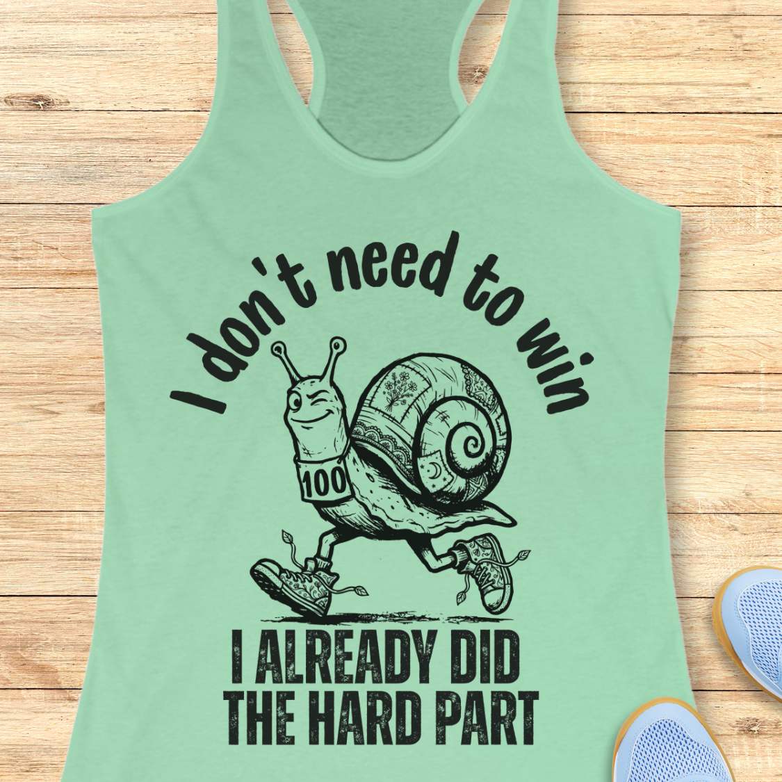 mint tank top with an image of  snail and text - I don't need to win I already did the hard part, on a wooden background