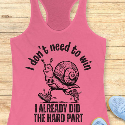 pink tank top with an image of  snail and text - I don't need to win I already did the hard part, on a wooden background