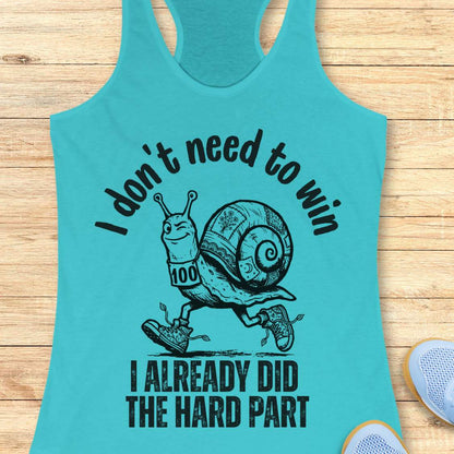 blue tank top with an image of  snail and text - I don't need to win I already did the hard part, on a wooden background
