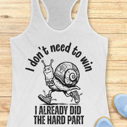 white tank top with an image of  snail and text - I don't need to win I already did the hard part, on a wooden background